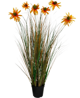 Der feuerhemmende Kunstgras-Chrysanthemen-Zwiebeltopf (90 cm) hat hohe, grüne und braune grasähnliche Blätter mit sieben orangefarbenen künstlichen Gänseblümchenblüten in einem schwarzen Topf vor einem weißen Hintergrund.